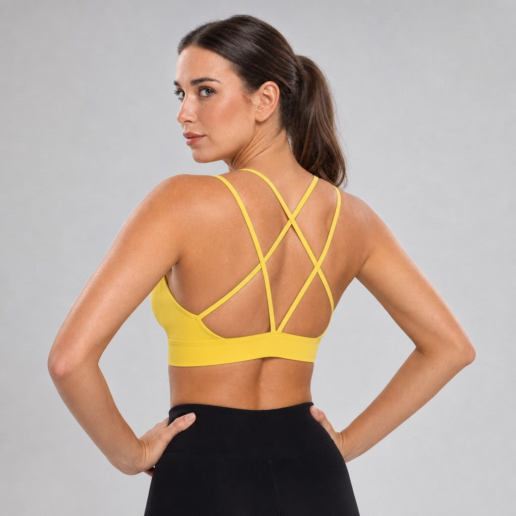 Model wearing NudeBlend Strappy Back Sports Bra in Yellow - criss-cross back