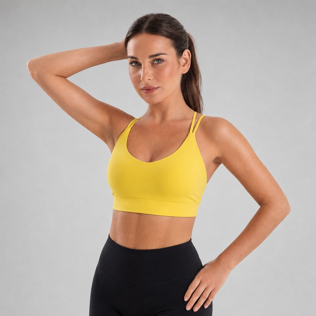 Model wearing NudeBlend Strappy Back Sports Bra in Yellow - front